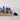 A photograph of a Flayou Chich Bich Chess set in blue clay with pieces off board.