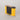Yellow and black Racina pinhole camera on a gray background from the left