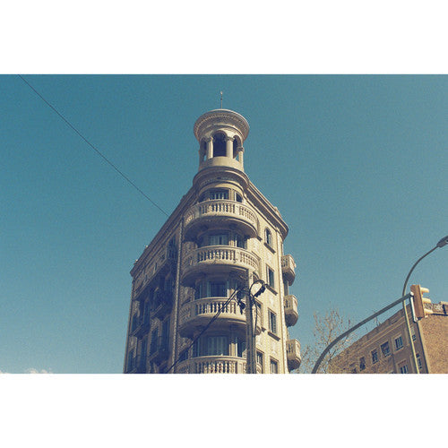 Tall building with decorative balconies against a clear blue sky