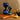 Three colored hourglasses on a book with a brown background