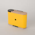 Yellow Racina 120 film camera from the back angle on a light gray background