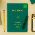 Green Penco notebook with stationery items on a beige background