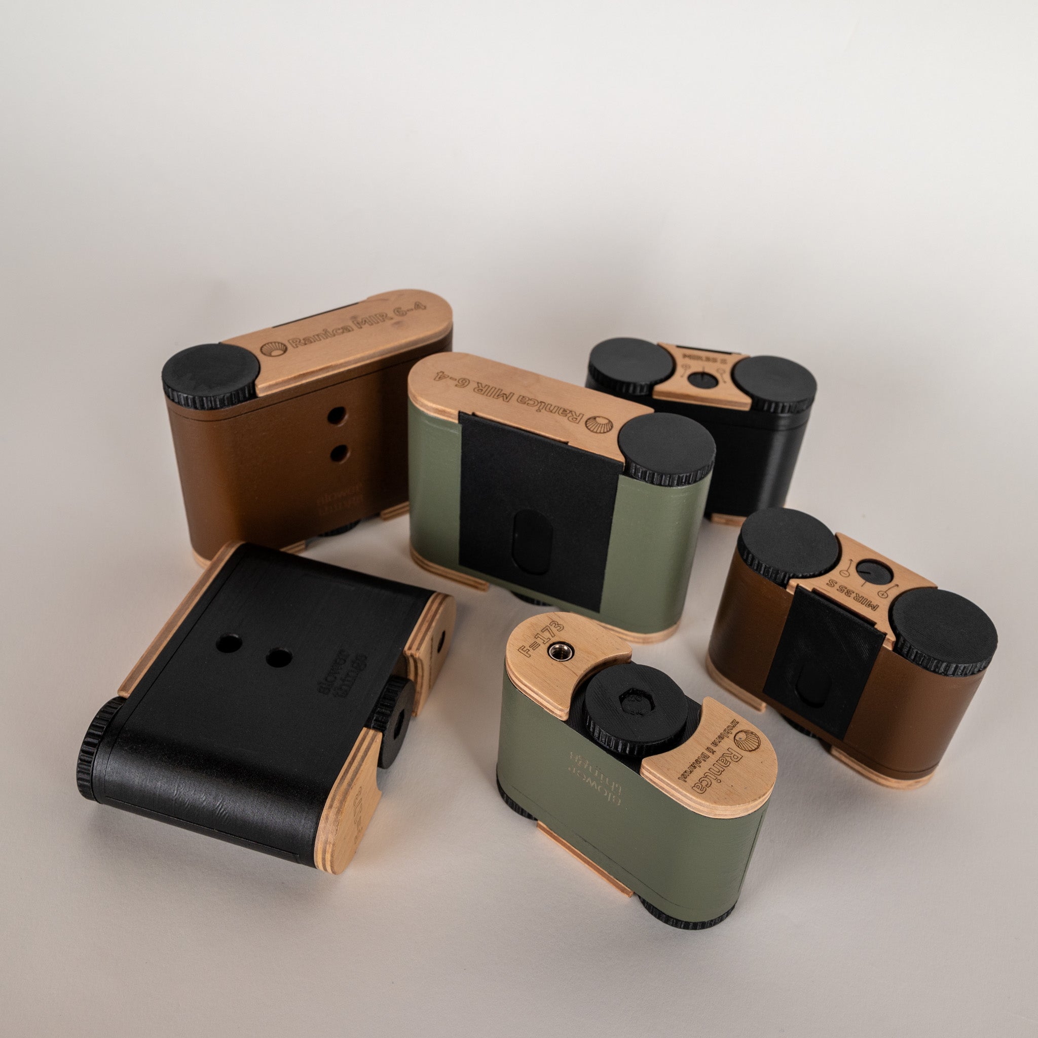A group of six ranica mir cameras in black, brown and olive green, both 35mm and 120 film models. 